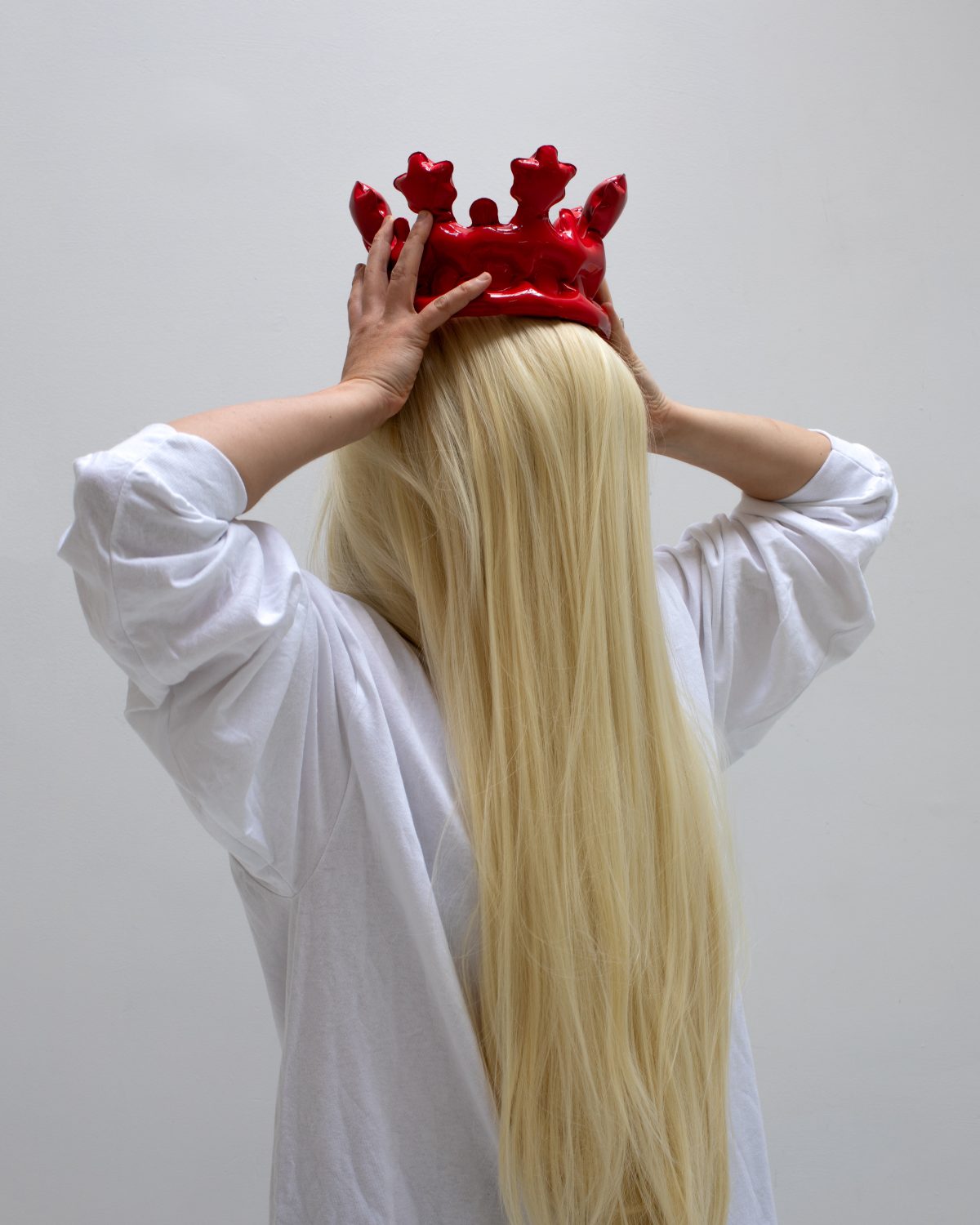 Woman holding red crown.